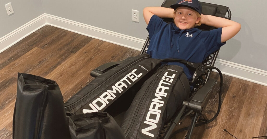 Youth Athlete Using NormaTec Compression Boots | St. Johns Chiropractic & Performance