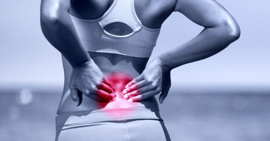 Woman with Back Pain Grabbing Her Back | Back Pain Relief | St. Johns Chiropractic & Performance