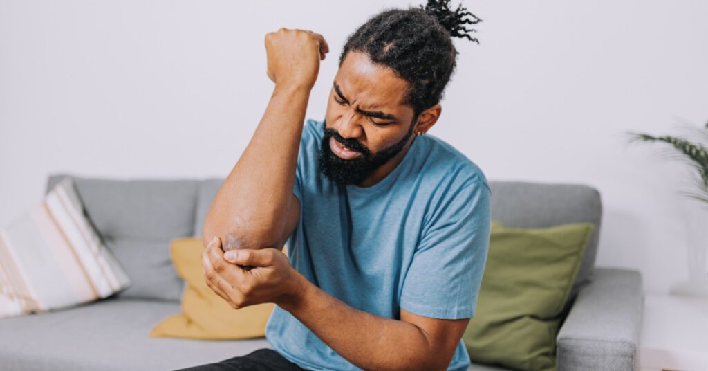 Man Holding His Elbow in Pain | Elbow Pain Relief | St. Johns Chiropractic & Performance
